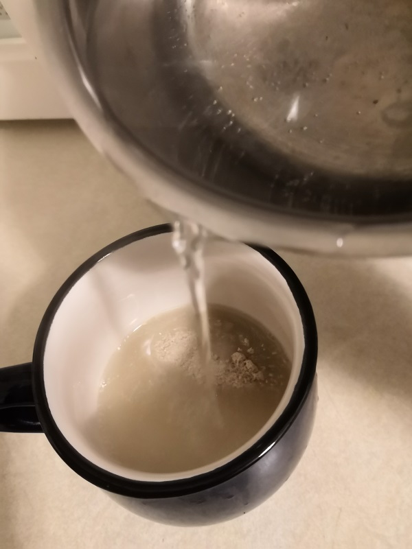 Pouring boiling water onto green coffee powder